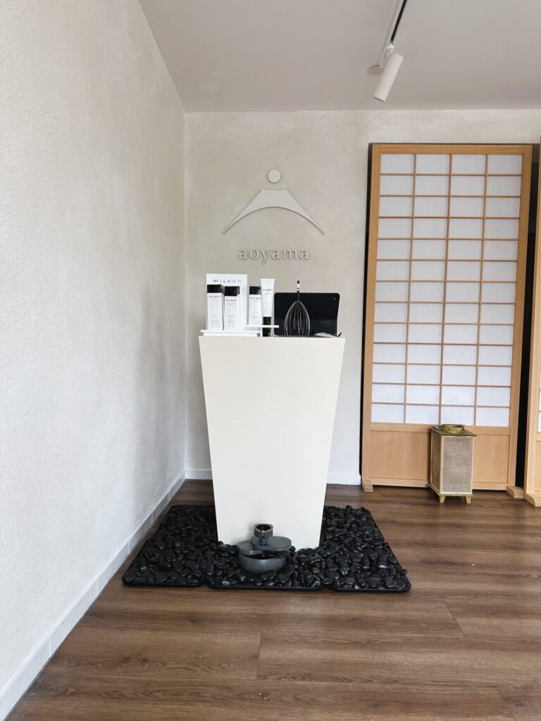 Minimalist treatment room with a small workstation and Japanese-style sliding door.